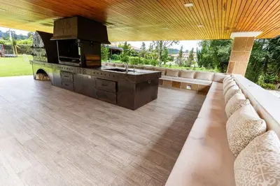 a large patio with a couch and a stove at Mansión de lujo La Reina Llanogrande in Rionegro