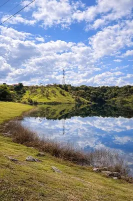 a body of water on a grassy field with a hill at Spacious Cabin with Garden and Lake Access, Guatapé in Guatapé