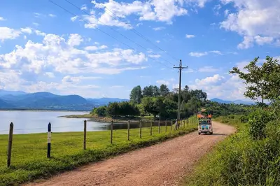 a truck driving down a dirt road next to a river at Spacious Cabin with Garden and Lake Access, Guatapé in Guatapé