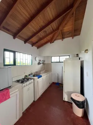 a kitchen with white cabinets and a refrigerator at Spacious Cabin with Garden and Lake Access, Guatapé in Guatapé