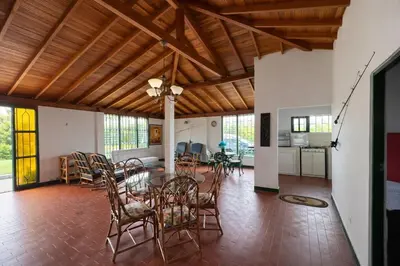 a dining room and living room with a table and chairs at Spacious Cabin with Garden and Lake Access, Guatapé in Guatapé