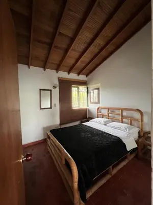 a bedroom with a large bed with a wooden frame at Spacious Cabin with Garden and Lake Access, Guatapé in Guatapé