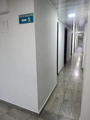 a hallway in a building with a sign on a wall at Hotel La Curva Parrilla Bar Confort in San Carlos