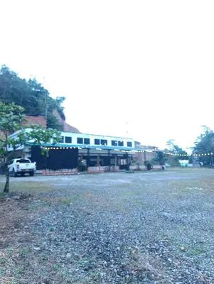 a large parking lot with a building in the background at Hotel La Curva Parrilla Bar Confort in San Carlos