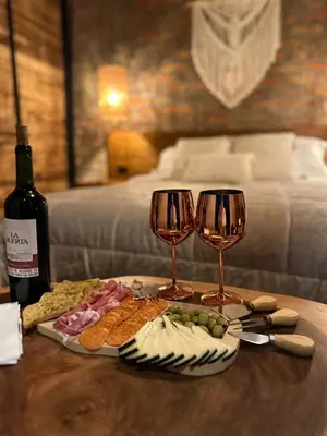 a table with two wine glasses and a plate of food at EntreNubes Hospedaje de Alta Montaña