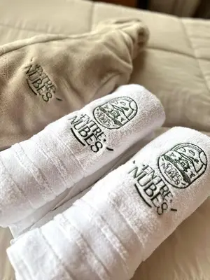 two rolled up towels on top of a bed at EntreNubes Hospedaje de Alta Montaña
