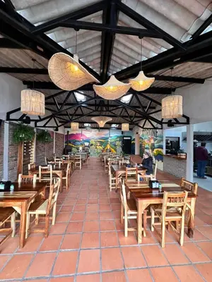 a restaurant with wooden tables and chairs and lights at EntreNubes Hospedaje de Alta Montaña