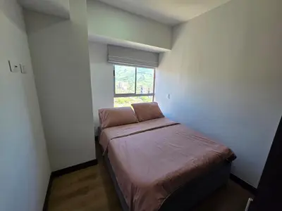 a small bedroom with a bed and a window at Modern sky high apartment in La Estrella in La Estrella