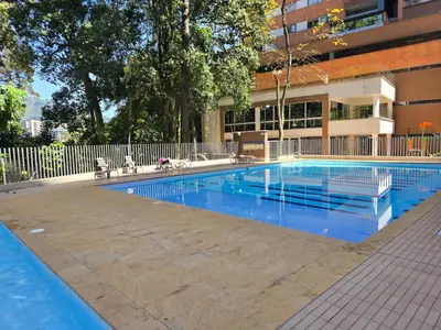 a swimming pool in front of a building at Modern sky high apartment in La Estrella in La Estrella