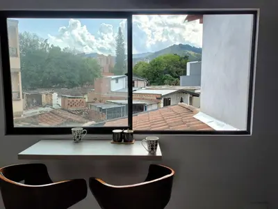 a window with two chairs in front of a table at Apartamento Independiente y Completo Gran Ubicación, La 80 Belén in Medellín