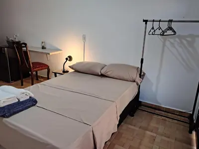 a bedroom with a bed and a table and a lamp at Cómodo Apartamento Independiente Primer Piso - Belén La 80 in Medellín