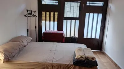 a large bed in a room with two windows at Cómodo Apartamento Independiente Primer Piso - Belén La 80 in Medellín