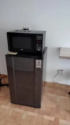 a microwave oven sitting on top of a refrigerator at Cómodo Apartamento Independiente Primer Piso - Belén La 80 in Medellín