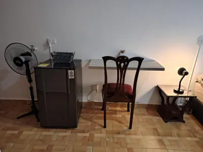 a room with a chair and a table with a fan at Cómodo Apartamento Independiente Primer Piso - Belén La 80 in Medellín