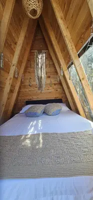 a bedroom with a bed in a wooden attic at Glamping Eros in Medellín