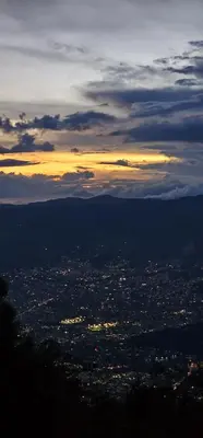 a view of a city at sunset from a mountain at Glamping Eros in Medellín