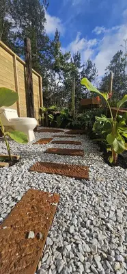 a garden with a stone walkway with a bench and a chair at Glamping Eros in Medellín