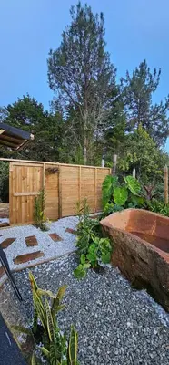 a garden with a wooden fence and a wooden tub at Glamping Eros in Medellín