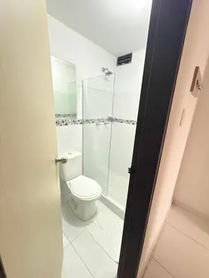 a bathroom with a toilet and a glass shower at Hotel California Blue Manizales in Manizales