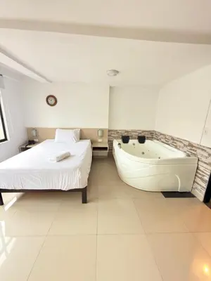 a bedroom with a bed and a bath tub next to a bed at Hotel California Blue Manizales in Manizales