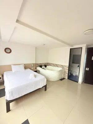 a bedroom with a bed and a bath tub at Hotel California Blue Manizales in Manizales