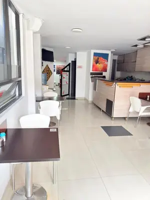 a kitchen with white floors and white chairs and tables at Hotel California Blue Manizales in Manizales