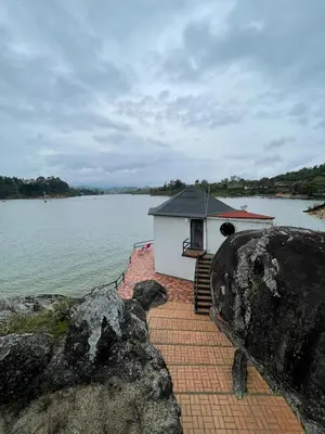 a small building on the side of a body of water at Finca la cruz, frente al embalse in Chiquinquirá