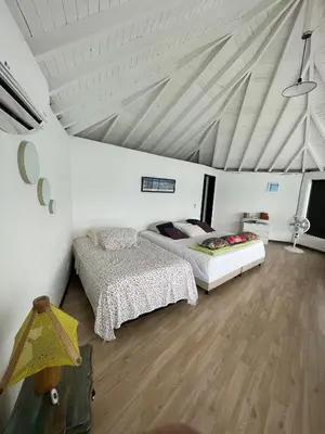 a bedroom with two beds and a white ceiling at Finca la cruz, frente al embalse in Chiquinquirá