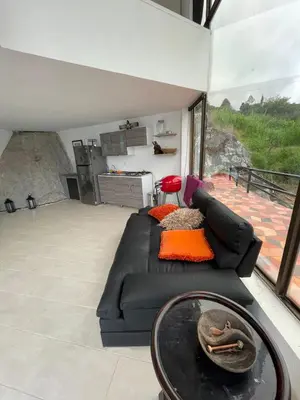 a living room with a black couch and a table at Finca la cruz, frente al embalse in Chiquinquirá