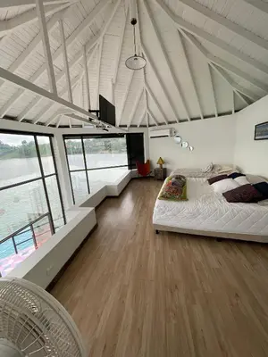 a bedroom with a large bed in a room with windows at Finca la cruz, frente al embalse in Chiquinquirá