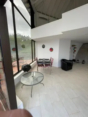 a living room with a table and chairs and a view at Finca la cruz, frente al embalse in Chiquinquirá