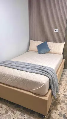 a bed with a blue pillow on top of it at Hermoso apartamento nuevo ! A un paso de la 70 zona vip in Medellín