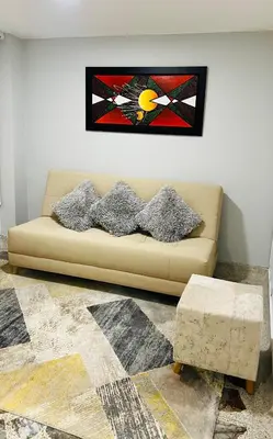 a living room with a couch with a picture on the wall at Hermoso apartamento nuevo ! A un paso de la 70 zona vip in Medellín
