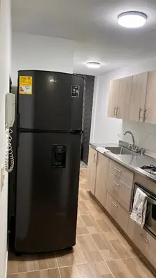 a black refrigerator in a kitchen with a sink at Hermoso apartamento nuevo ! A un paso de la 70 zona vip in Medellín