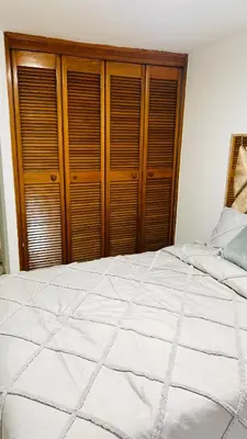 a bedroom with a large white bed with wooden cabinets at Hermoso apartamento nuevo ! A un paso de la 70 zona vip in Medellín