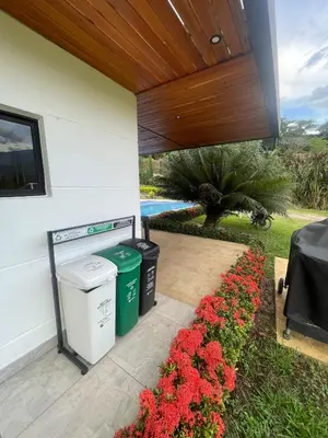 a patio with two trash cans and red flowers at FIincaVilla Cavil a 50 min de Medellin in Sopetran