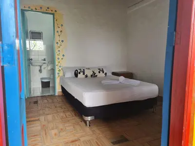 a bedroom with a bed and a bathroom with a sink at Aldea Los Pioneros in Venecia