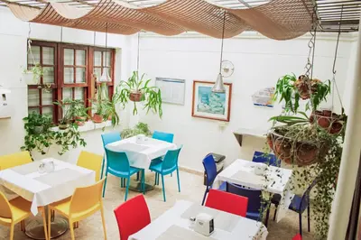 a restaurant with tables and chairs and plants at Hostel North SAS in Medellín