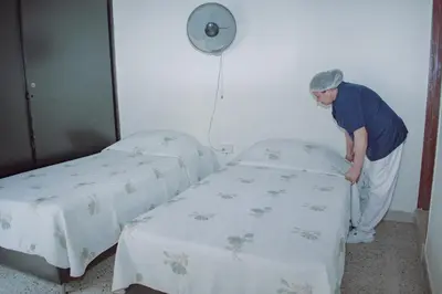 a man standing between two beds in a room at Hostel North SAS in Medellín