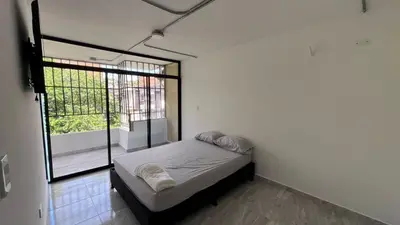 a small bedroom with a bed and a window at Acogedor Loft Medellin cerca al Estadio Atanasio in Medellín
