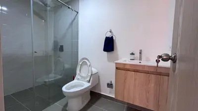 a bathroom with a toilet and a glass shower at Acogedor Loft Medellin cerca al Estadio Atanasio in Medellín