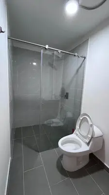 a bathroom with a toilet with a glass shower stall at Acogedor Loft Medellin cerca al Estadio Atanasio in Medellín