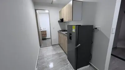 a small kitchen with a refrigerator in a room at Alojamiento entero loft en Medellin, Estadio in Medellín