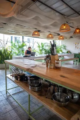 a woman is sitting at a table in a kitchen at Co404 Medellin - Coliving Coworking in Medellín