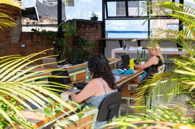 two women sitting at tables in an office at Co404 Medellin - Coliving Coworking in Medellín
