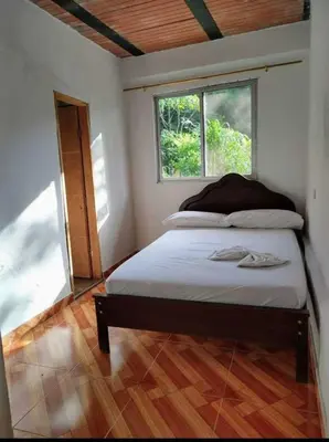 a bedroom with a bed in a room with a window at Finca Mi Delirio in Cocorná