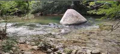 a large rock sitting in the middle of a river at WalApar in San Rafael
