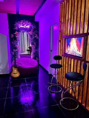a bedroom with a purple room with a bed and two stools at Charlotte Alojamiento in Medellín