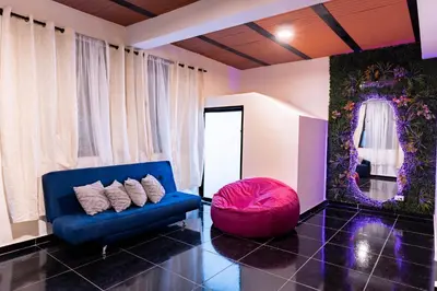 a living room with a blue couch and a red ottoman at Charlotte Alojamiento in Medellín