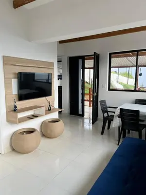 a living room with a television and a table and chairs at Charlotte Alojamiento in Medellín